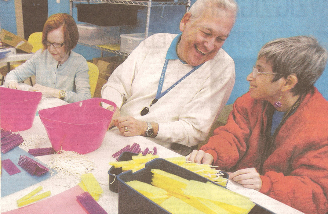 Volunteers Paulette Bregman, left, and Shelly Bleiweiss, center, help Carri Cowen make candles out of colorful beeswax.